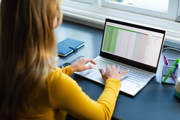 focused-caucasian-woman-sitting-at-desk-working-on a compliance gap analysis