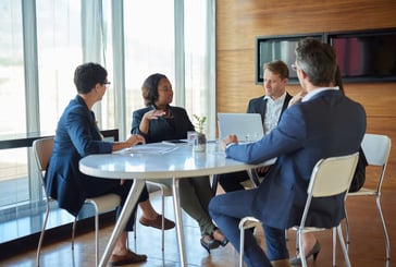  group of professionals in business attire engaged in a discussion