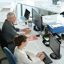 colleagues sitting next to each other working on computers